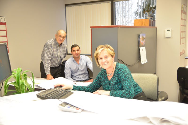 Three employees in office environment collaborating. 